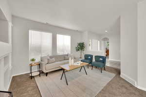 Carpeted living area featuring arched walkways, healthy amount of natural light, recessed lighting, and tile patterned flooring