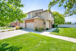 Traditional-style house featuring a garage, stucco siding, and driveway