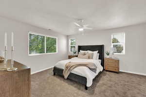 Carpeted bedroom featuring multiple windows, a ceiling fan, and a textured ceiling