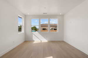Empty room featuring light wood-style floors and recessed lighting