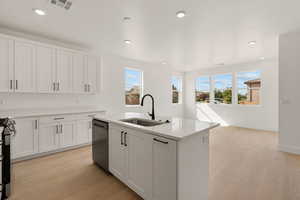 Kitchen with light wood finished floors, white cabinetry, a kitchen island with sink, recessed lighting, and dishwasher
