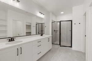 Bathroom with double vanity, a stall shower, recessed lighting, light tile patterned floors, and a spacious closet