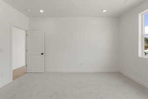 Empty room featuring light carpet and recessed lighting