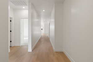 Corridor featuring light wood finished floors and recessed lighting