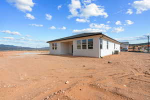 Rear view of property featuring a patio, a mountain view, and stucco siding