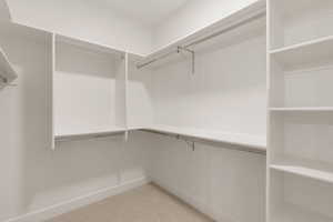 Spacious closet featuring light colored carpet