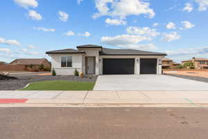 Prairie-style home featuring stucco siding, driveway, a garage, and a tile roof
