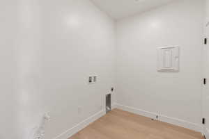 Washroom featuring light wood-type flooring, hookup for a washing machine, electric dryer hookup, and hookup for a gas dryer
