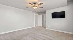 Spare room featuring light carpet, a textured ceiling, and ceiling fan
