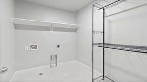 Washroom featuring electric dryer hookup, washer hookup, and light tile patterned floors