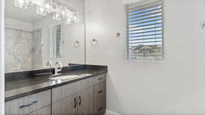 Bathroom featuring vanity and a tile shower