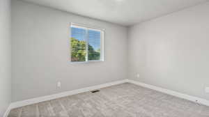 Carpeted spare room featuring baseboards and a textured ceiling