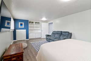 Bedroom featuring a textured ceiling and wood finished floors