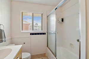 Full bath featuring vanity, enclosed tub / shower combo, and tile patterned floors