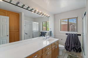 Bathroom with a stall shower, vanity, and tile patterned floors