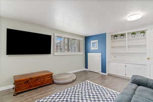 Living room with a textured ceiling and light wood-type flooring