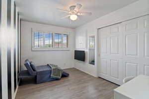 Living area featuring light wood-type flooring and a ceiling fan