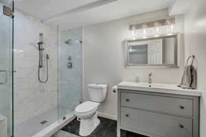 Bathroom featuring a shower stall, vanity, and a textured ceiling