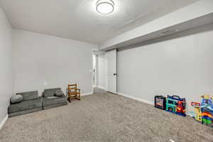Living area featuring carpet flooring and baseboards