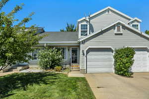 View of front facade featuring concrete driveway, a front lawn, a garage, entry steps, and a shingled roof