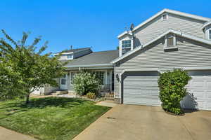 Traditional-style home with driveway, a front lawn, and roof with shingles