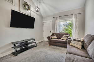 Living room featuring lofted ceiling and carpet