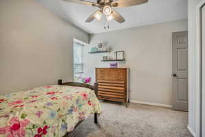 Carpeted bedroom with baseboards and ceiling fan