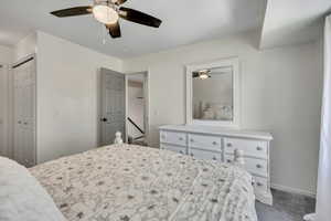 Carpeted bedroom with a closet and a ceiling fan
