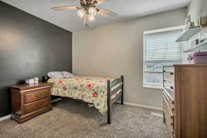 Carpeted bedroom with baseboards and a ceiling fan