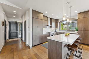 Kitchen featuring a breakfast bar, light wood-type flooring, healthy amount of natural light, appliances with stainless steel finishes, and recessed lighting