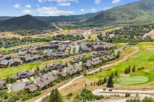 Aerial perspective of suburban area featuring a golf course and mountains