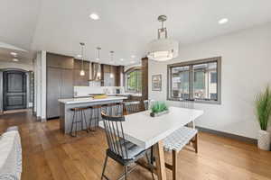 Dining room with hardwood / wood-style floors, recessed lighting, and arched walkways