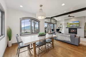 Dining area with wood-type flooring, a glass covered fireplace, recessed lighting, and ceiling fan