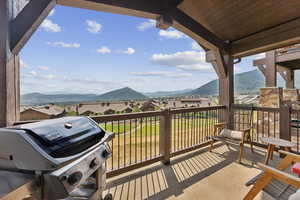 Balcony featuring grilling area, a residential view, and a mountain view
