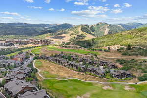 Aerial overview of property's location featuring a local golf course and nearby suburban area
