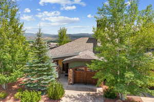 View of property's community featuring concrete driveway, a mountain view, and a garage