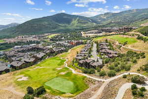 Aerial view of residential area with a golf club and mountains