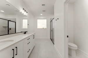 Bathroom with a stall shower, double vanity, and light tile patterned flooring