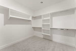 Walk in closet with light colored carpet