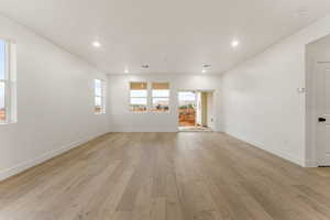 Spare room featuring plenty of natural light, light wood-type flooring, and recessed lighting