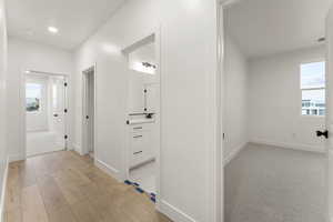 Hallway with baseboards and light wood finished floors