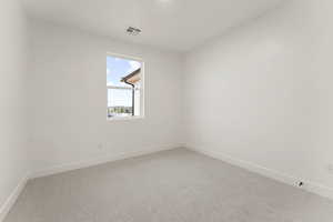 Carpeted spare room featuring baseboards