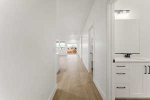Corridor featuring light wood finished floors and baseboards