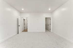 Unfurnished bedroom with light carpet and recessed lighting