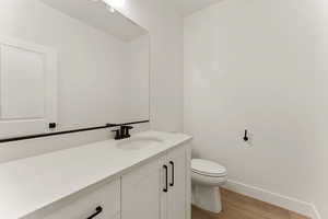 Half bathroom featuring light wood finished floors and vanity