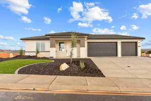 Prairie-style house with concrete driveway, an attached garage, brick siding, stucco siding, and a tiled roof