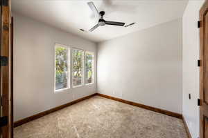 Unfurnished room featuring a ceiling fan and carpet