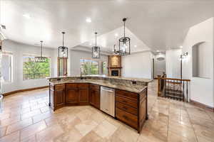 Kitchen featuring dishwasher, a raised ceiling, recessed lighting, and light stone countertops