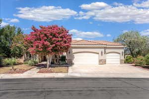 View of front of house featuring stone siding, a garage, stucco siding, concrete driveway, and a tile roof