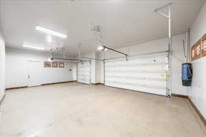 Garage with baseboards and a garage door opener